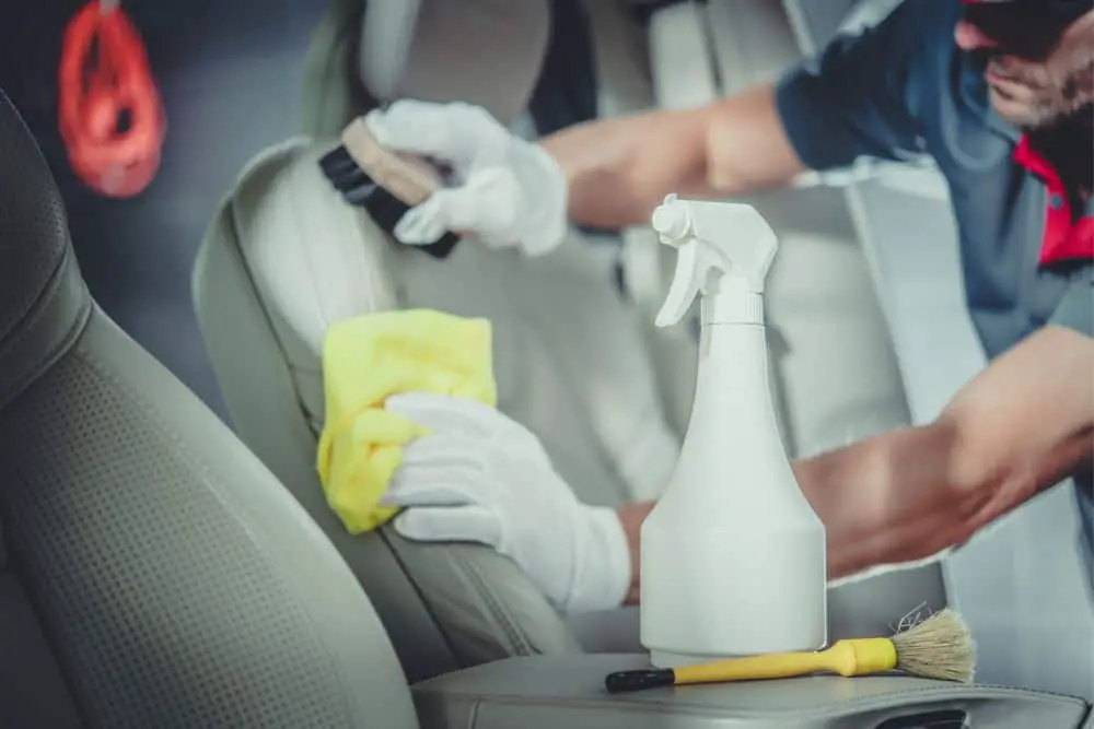 A man is scrubbing the car seat